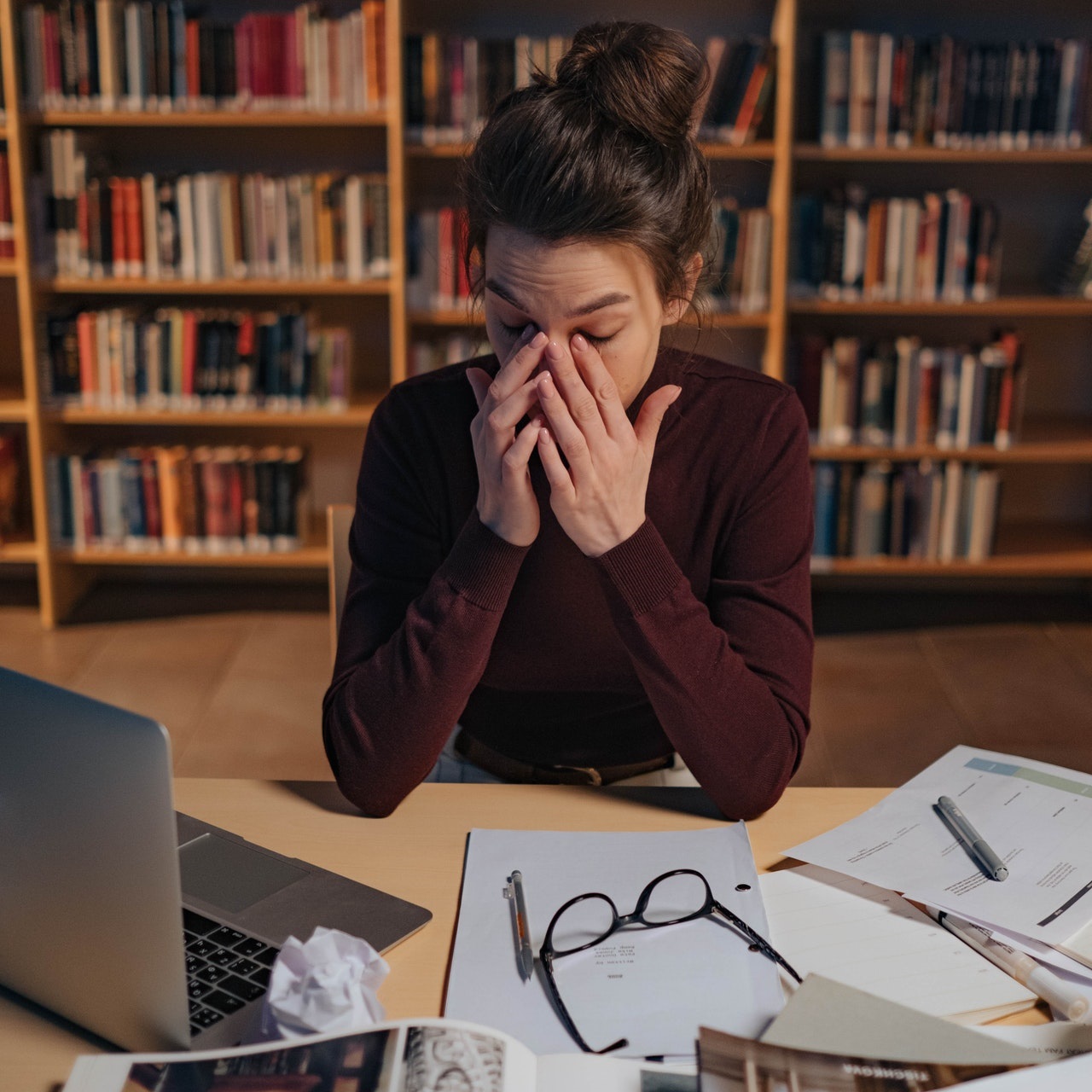 kobieta siedząca przy komputerze, przecierająca oczy, widocznie zmęczona i zestresowana